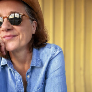 Susan Werner looking off into the distance wearing sunglasses and a blue shirt Promo Shot for Halfway to Houston in RGB format
